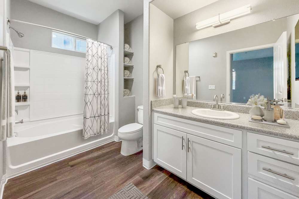 A well-decorated bathroom with wooden cabinets at The Lofts in Sacramento, California