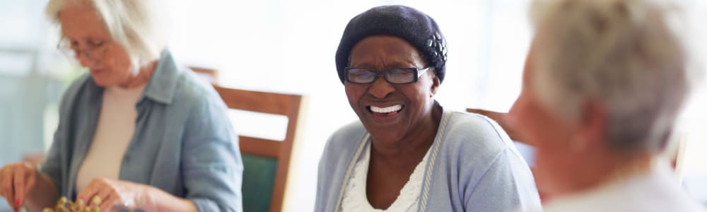 Resident smiling sitting up to a dining table at East Troy Manor in East Troy, Wisconsin