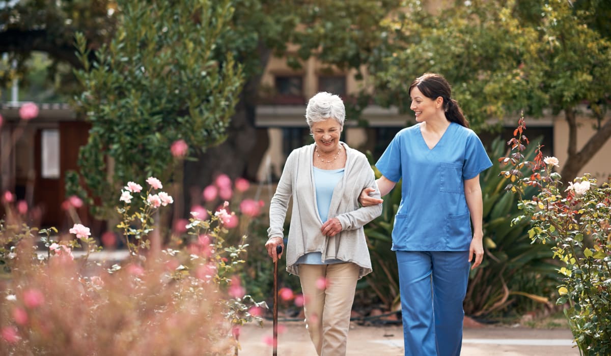 A staff member on a walk with a resident near CERTUS Premier Memory Care Living in Orange City, Florida.