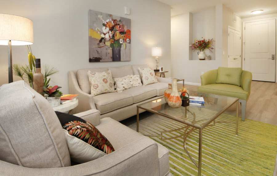 Cozy living room with vibrant artwork and modern furnishings at Messina Luxury Apartments in New Smyrna Beach, Florida