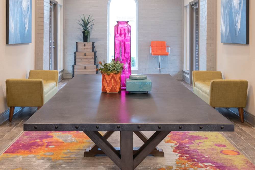 Vibrant communal space featuring a modern table and chic seating at Charter Oak in Euless, Texas.