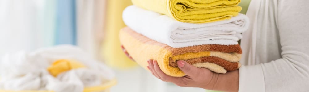 Caregiver with freshly folded towels at Villas At Maple Ridge in Spooner, Wisconsin