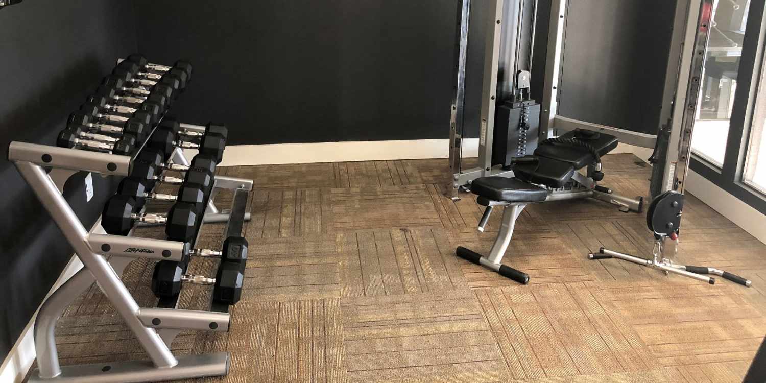Weights and strength training equipment in the fitness center at Branch Creek Apartments in Carrollton, Texas