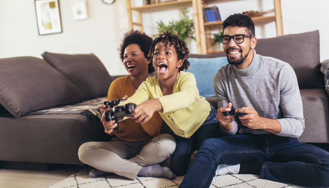 Family playing video games at Woodcreek Apartments in Huntsville, Texas