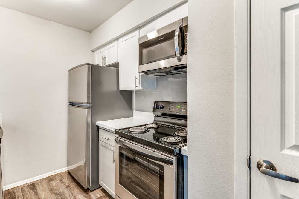 Kitchen with stove, refrigerator and microwave at Tribecca Pointe Apartments in Hurst, Texas
