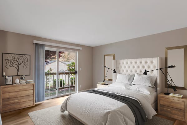Beautifully decorated model bedroom with sliding door access to a private patio at Chandlers Bay Apartments in Kent, Washington