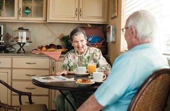 Senior living couple at Discovery Commons At Wildewood in California, Maryland assisted living dine together