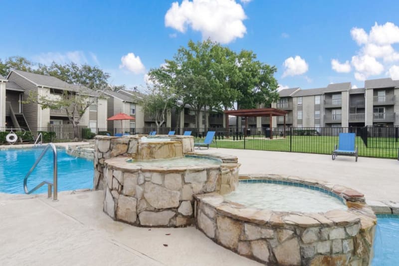 Adjacent spa with waterfall at outdoor pool at Circle at Point Park in Houston, Texas