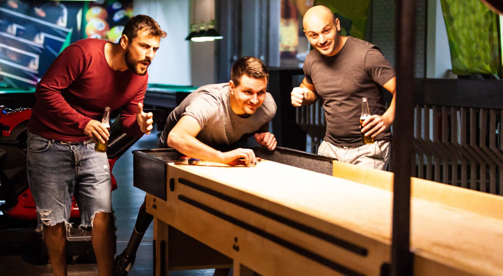 Three men playing shuffle board at The Colton in Redwood City, California