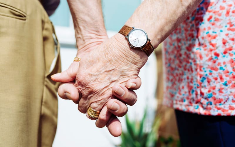 Two residents holding hands at Grand Villa of St. Petersburg in St. Petersburg, Florida