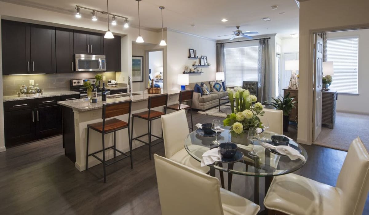 Bright kitchen and dining room with dark flooring at The Crossing at Katy Ranch in Katy, Texas