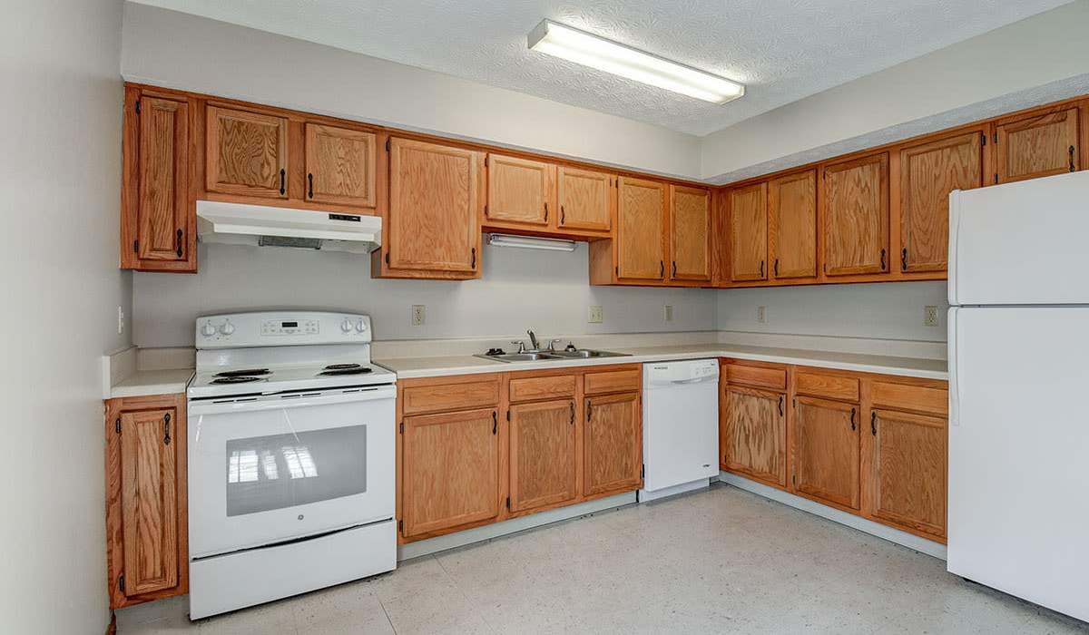 Wooden cabinets and white appliances in model home kitchen at Edwards Crossing I in Beaver, West Virginia