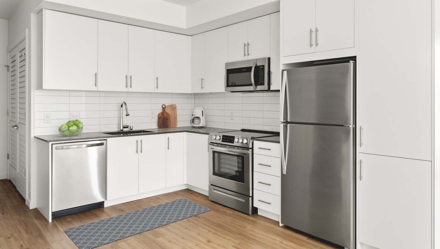 Kitchen with wood-style flooring at Helm in Everett, Washington