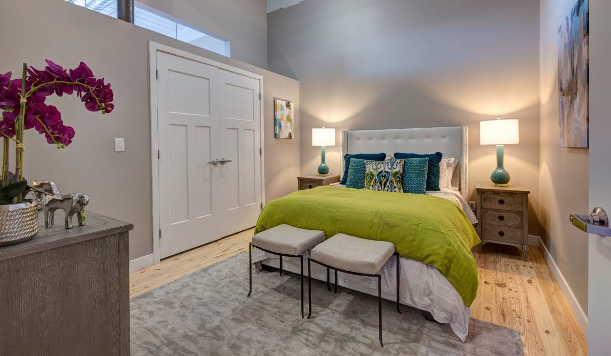 Garden style bed with green blanket and decorative pillows at Commonwealth Landing Lofts in Fall River, Massachusetts