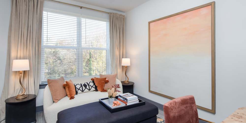 Living room with a couch, table and a large window at Vine North Hills in Raleigh, North Carolina