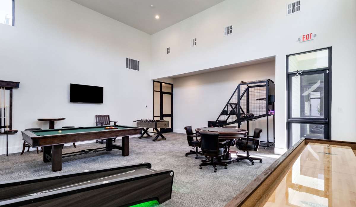 Game room featuring pool table, foosball, and seating area with modern decor and high ceilings at Lakewood Villas in Bossier City, Louisiana