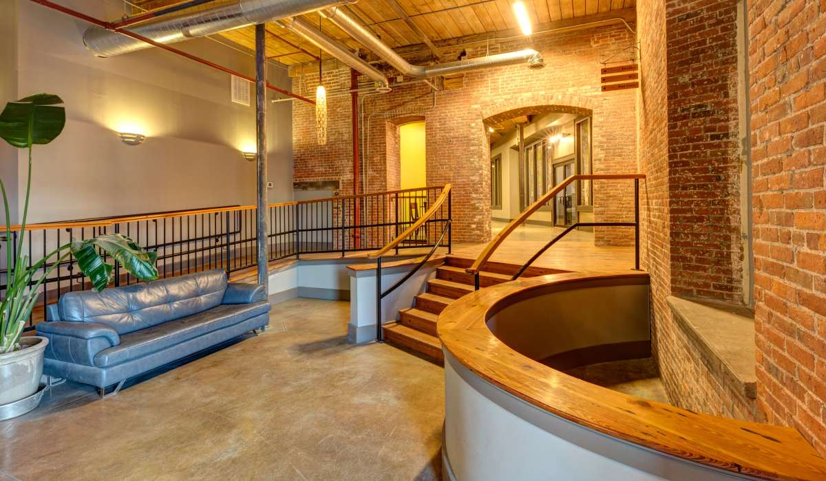New blue sofa with potted plant and brick walls at Commonwealth Landing Lofts in Fall River, Massachusetts