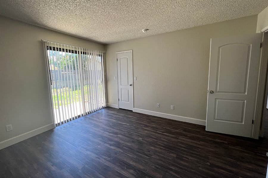 Model living room with sliding glass door at Ashford Park in Sacramento, California