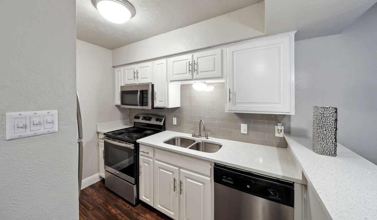 Kitchen with range and wooden cabinets at Aberdeen at Bellmar in Dallas, Texas