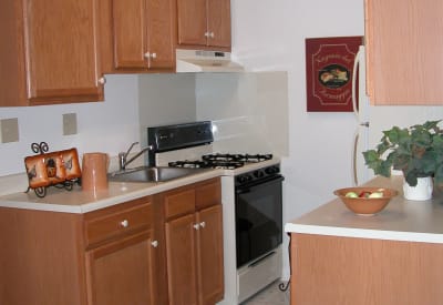 Recently renovated kitchen with stainless-steel appliances and dark wood cabinetry in model townhome at Westgate Apartments & Townhomes in Manassas, Virginia