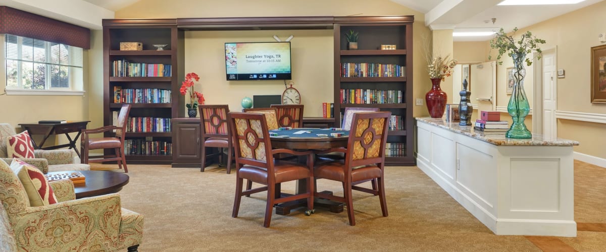 Community lounge area with TV and card tables at The Commons on Thornton in Stockton, California