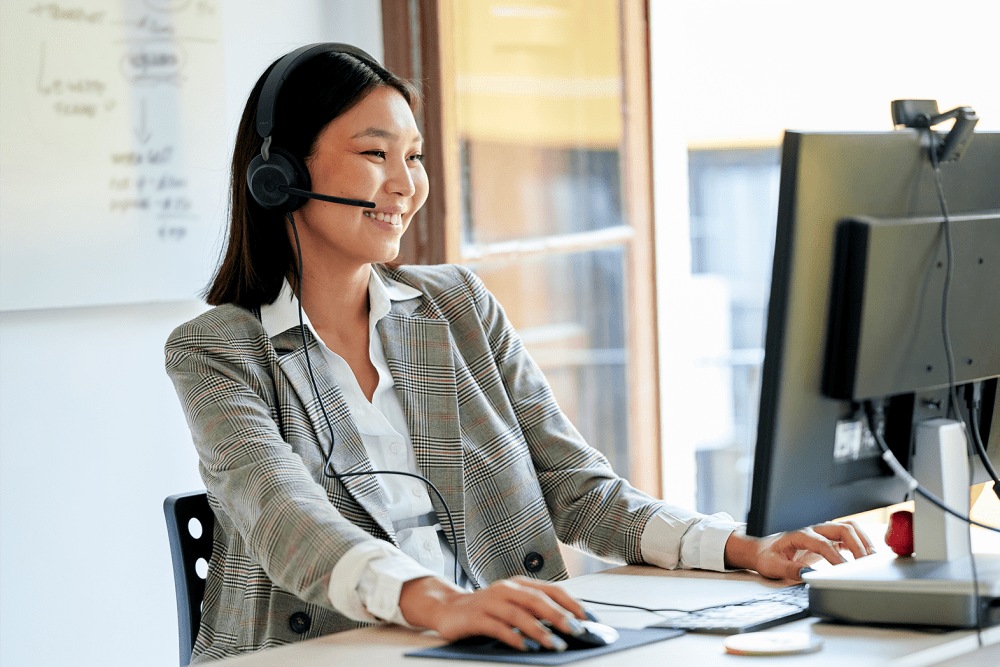 Person sitting at a desk and working at a computer while wearing a headset at Robbins Property Associates, LLC in Tampa, Florida