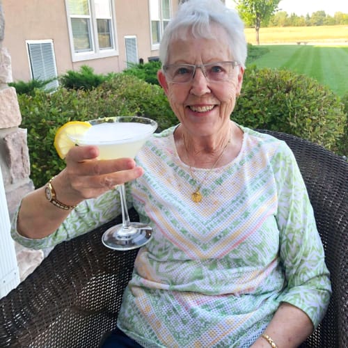 Resident sitting outside with a mixed drink at The Oxford Grand Assisted Living & Memory Care in Wichita, Kansas