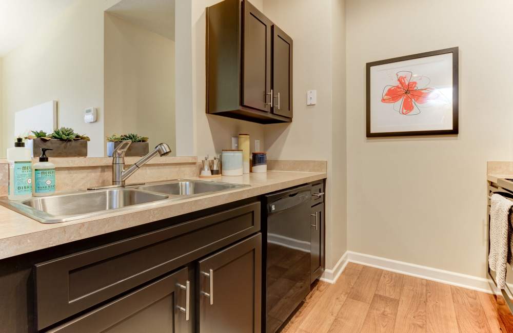 Kitchen with black appliances and wood flooring at The Bradford at Easton Apartments & Townhomes in Columbus, Ohio