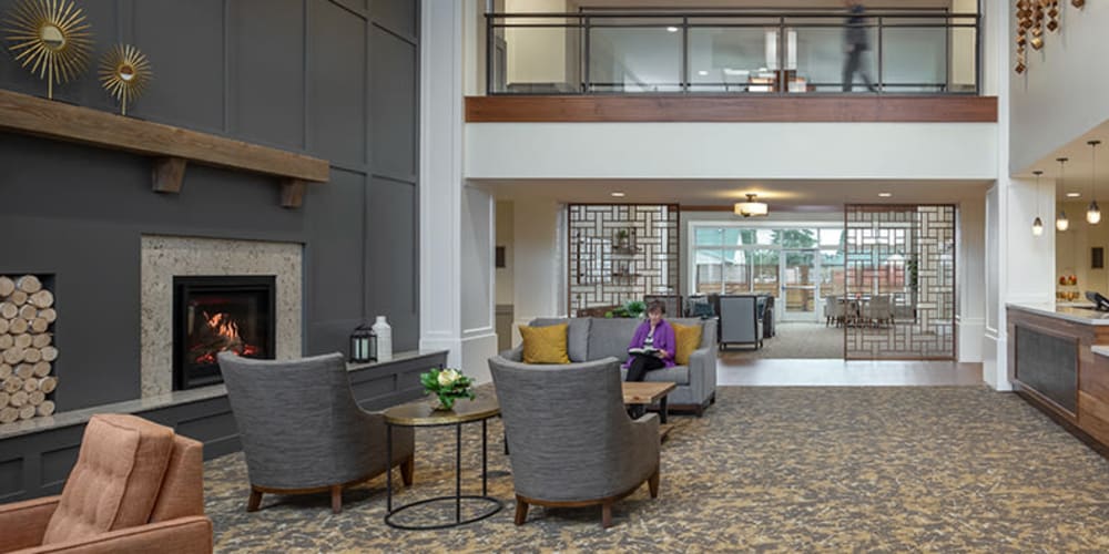 Brightly lit upscale senior living lobby complete with wood accents, comfy armchairs, and modern vaulted ceilings at The Springs at Sherwood in Sherwood, Oregon