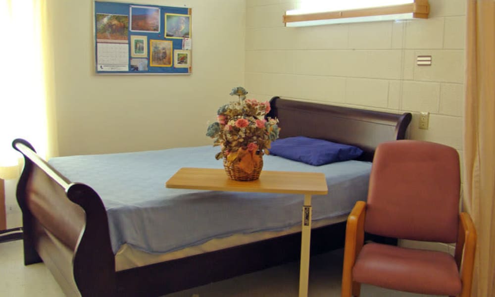 Cozy and comfortable sleigh style bed at Montello Care Center in Montello, Wisconsin