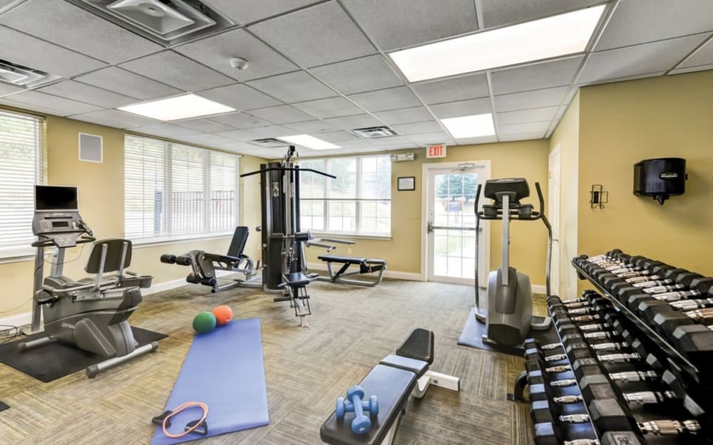 Well-equipped fitness center with cardio equipment at Village Square Apartments & Townhomes in Glen Burnie, Maryland