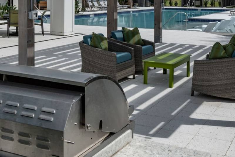 Outdoor grilling area with seating and places to cook poolside at Reunion at 400 in Kissimmee, Florida