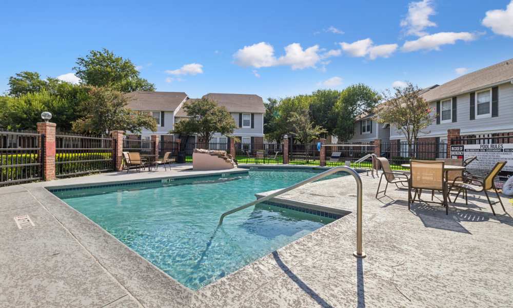 Outdoor seating area beside the pool at Arbors of Taylor in Taylor, Texas