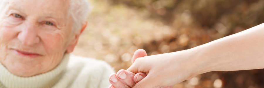 Resident holding hands with a younger family member at Edgerton Care Center in Edgerton, Wisconsin