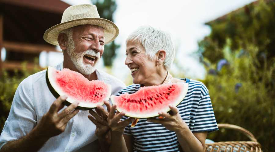 Residents embrace enjoying sliced watermelon at a Truewood by Merrill location