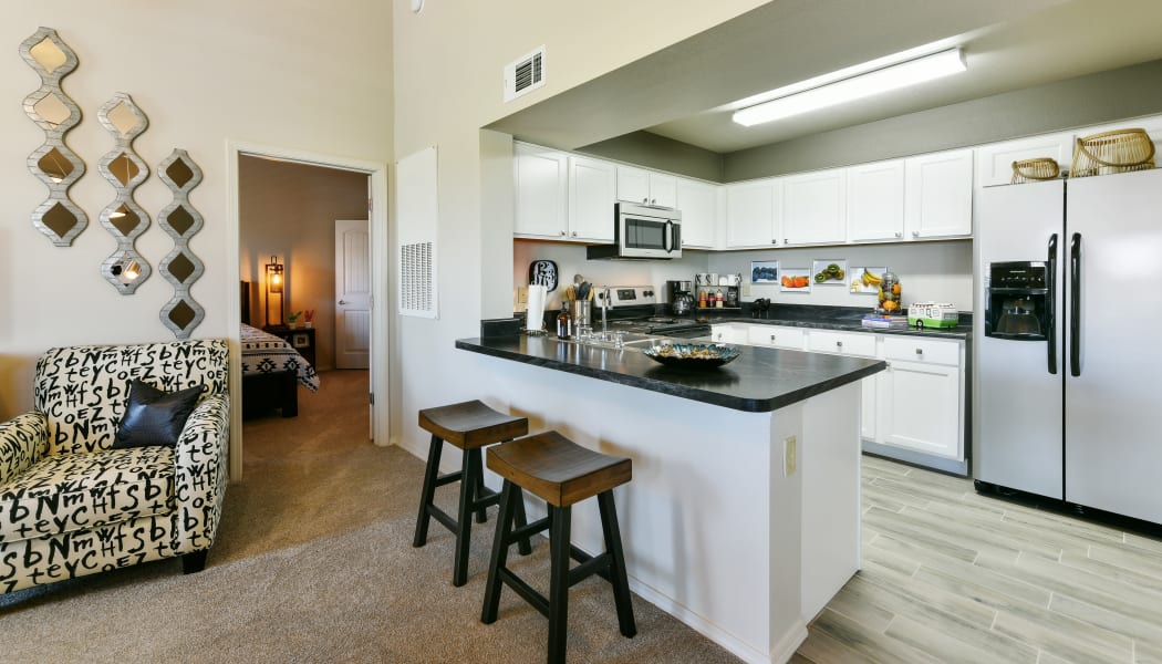 Kitchen with bar-style seating at Cottages at Abbey Glen Apartments in Lubbock, Texas