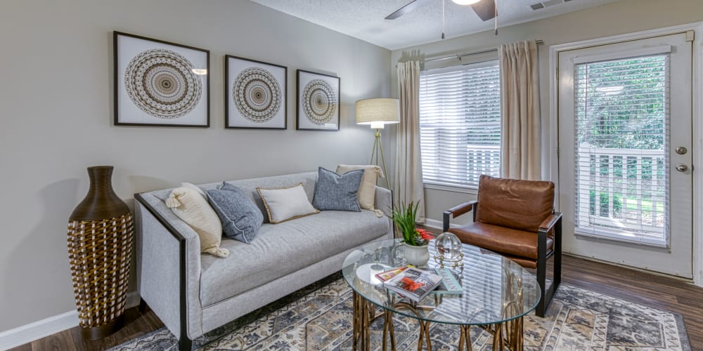 An apartment living room with balcony access at The Glen at Lanier Crossing in Stockbridge, Georgia