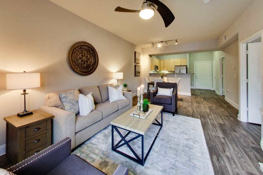 Open concept living and dining area with contemporary plank flooring and a ceiling fan in a model home at SouthPark Morrison in Charlotte, North Carolina