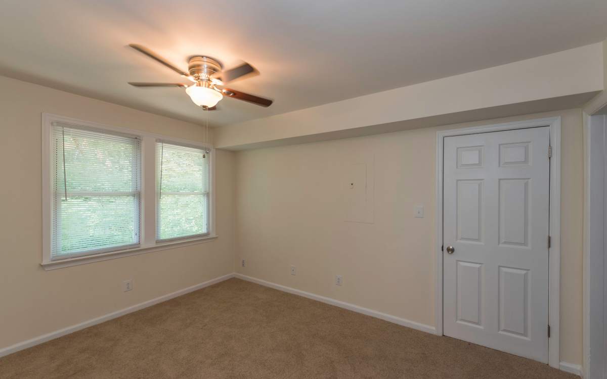 Bedroom with ceiling fan and carpet flooring at Fox Chase Apartments in Fredericksburg, Virginia