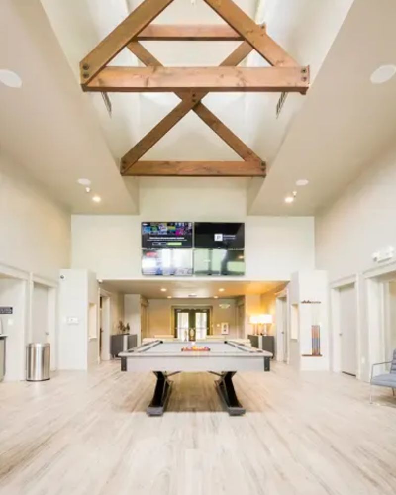 Upscale resident clubhouse with a pool table and multiple flatscreen TVs at Octave in Davis, California