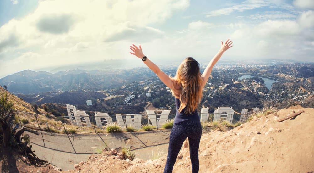 A resident stands above the Hollywood sign near The Tower at Hollywood Hills in Los Angeles, California