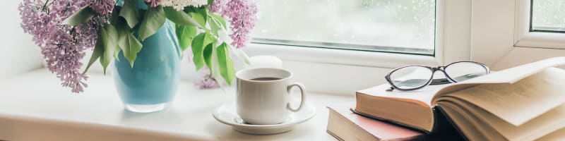 Hot beverage and books sitting near a window at Transitions At Home in Elkhorn, Wisconsin