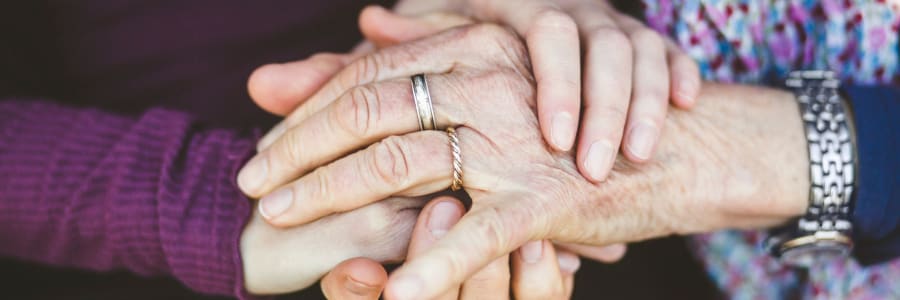 Caretaker hand-in-hand with a younger family member at Bell Tower Residence Assisted Living in Merrill, Wisconsin