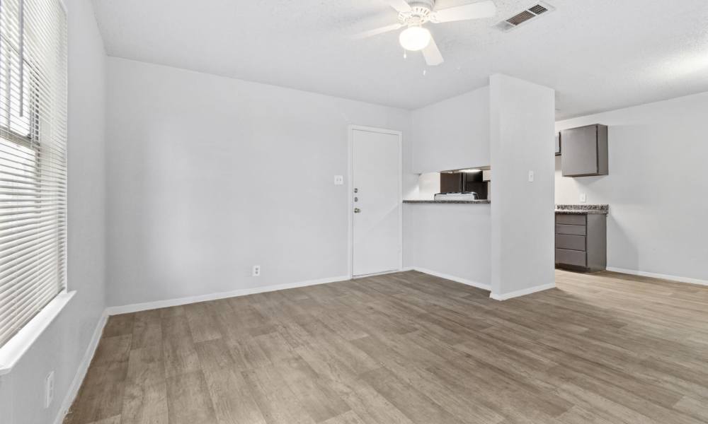 Wood-style flooring in the living area next to kitchen at Arbors of Taylor in Taylor, Texas