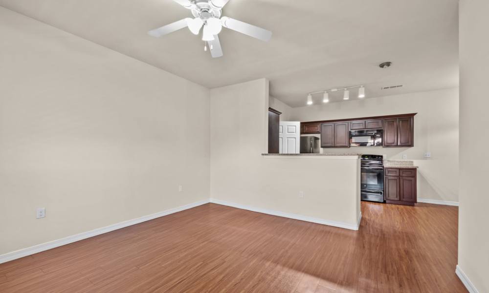 Wood-style floored living room with ceiling fan at Las Torres Apartments in El Paso, Texas