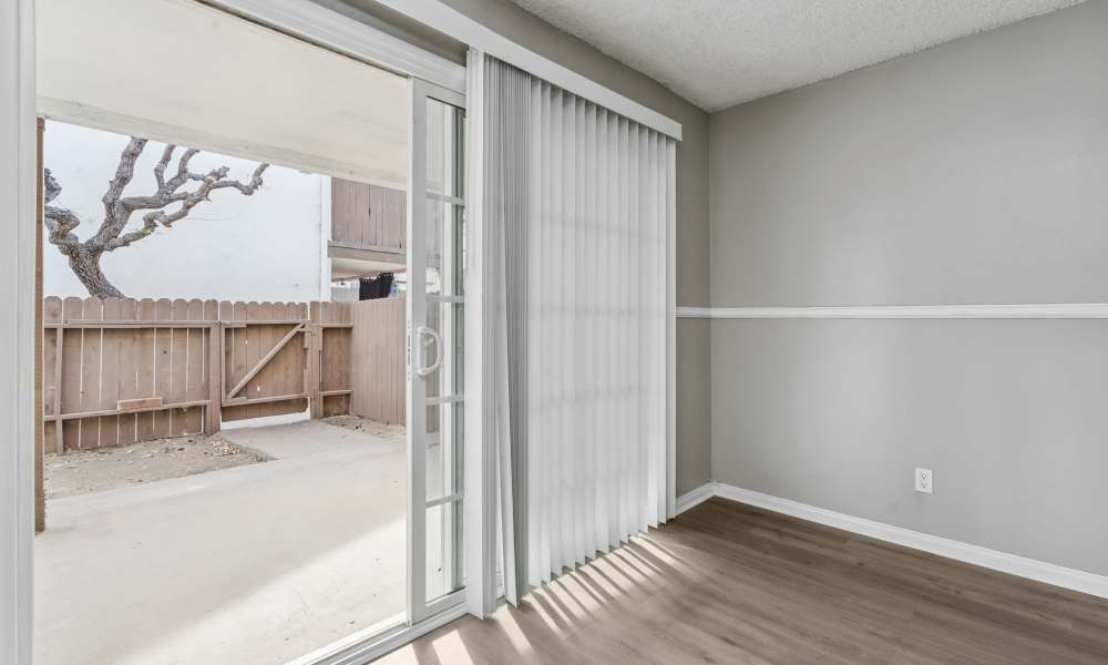 Living area with hard flooring looking out to patio at Newland Garden Apartments in Garden Grove, California