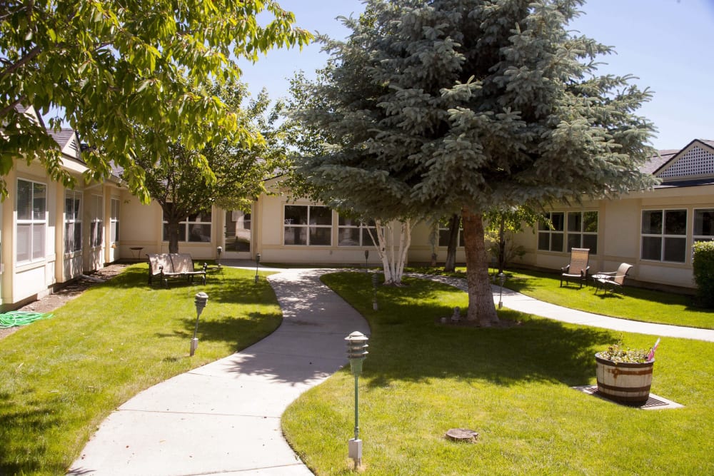 Walking paths and mature trees in the courtyard at Settler's Park Senior Living in Baker City, Oregon