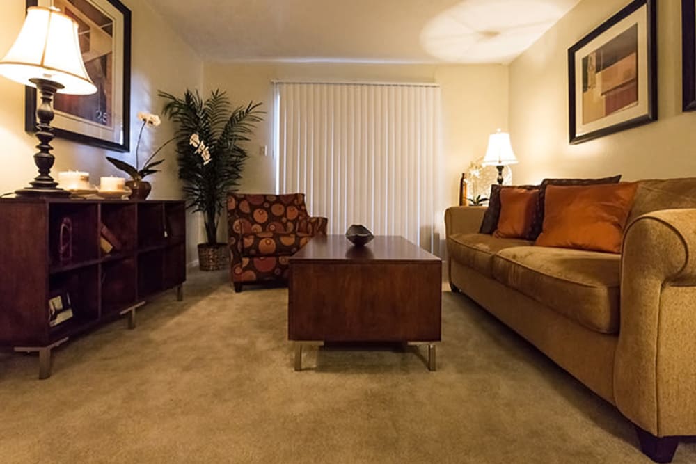 Model living room with patio access at Riverstone Apartments in Bryan, Texas