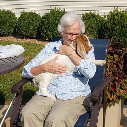 A resident sitting outside holding her dog at Alderbrook Village in Arkansas City, Kansas