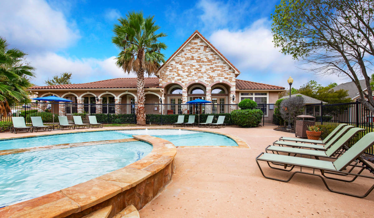 Swimming pool with patio and lounge chairs at Walnut Ridge Apartments, Bastrop, Texas